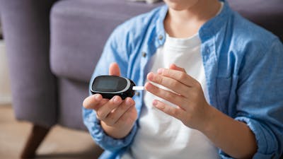 Little diabetic boy taking blood sample at home. World Diabetes Day, November 14