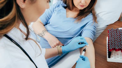 cropped view of donor and doctor with syringe obtaining blood sample