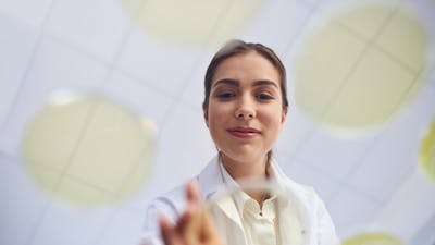 Low angle shot of a young scientist conducting an experiment in a lab.