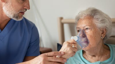 Portrait of a senior woman with inhaller, healthcare concept. Close-up of senior woman patient receiving oxygen mask.