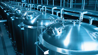 Industrial interior of modern craft brewery with chrome cylindrical metal beer tanks. Private microbrewery.